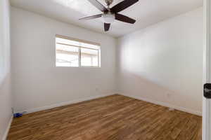 Empty room with ceiling fan, a textured ceiling, and dark hardwood / wood-style flooring