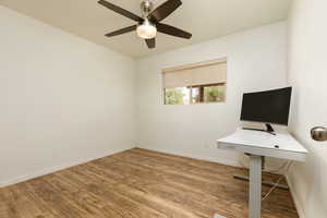 Unfurnished office with hardwood / wood-style floors and ceiling fan