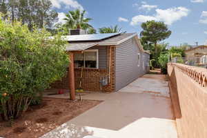 View of side of property with a patio and solar panels