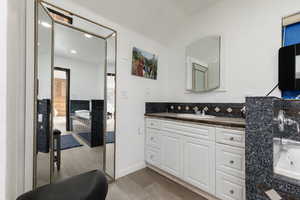 Bathroom with vanity, lofted ceiling, wood-type flooring, and a washtub