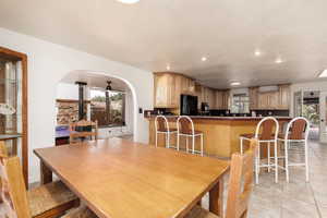 Dining space featuring light tile patterned floors and ceiling fan