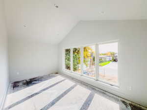 Unfurnished room featuring lofted ceiling