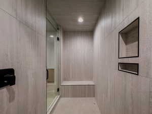 Bathroom featuring a shower and tile walls