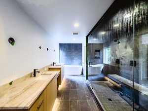 Bathroom featuring independent shower and bath, vanity, and tile patterned floors