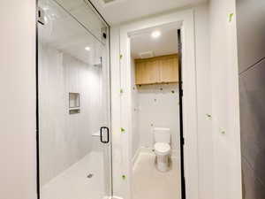 Bathroom featuring an enclosed shower, tile patterned floors, and toilet