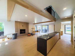 Kitchen featuring light wood-type flooring, a large fireplace, and a center island