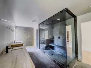 Bathroom featuring tile walls, sink, and a shower with shower door