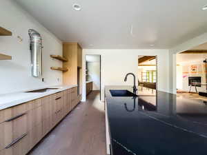 Kitchen featuring sink, light brown cabinetry, and dark hardwood / wood-style flooring