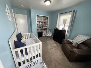 Bedroom with carpet and a textured ceiling