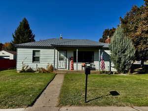 Bungalow-style home with a front lawn and covered porch