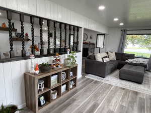 Living room with a stone fireplace and wood-type flooring