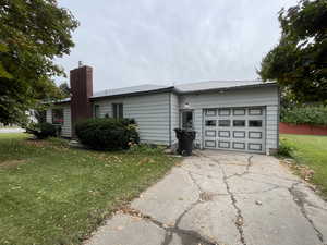 View of side of home featuring a lawn and a garage