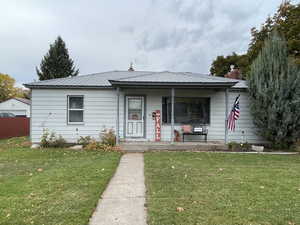 View of front of home with a front yard and a porch