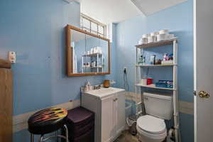 Bathroom featuring vanity, a textured ceiling, and toilet