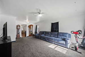 Carpeted living room featuring ceiling fan