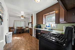 Kitchen with black appliances, wood-type flooring, a textured ceiling, and ceiling fan