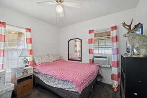 Carpeted bedroom with ceiling fan and cooling unit