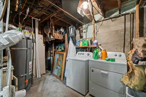 Washroom featuring water heater and washer and dryer