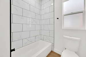 Bathroom featuring toilet and tiled shower / bath combo