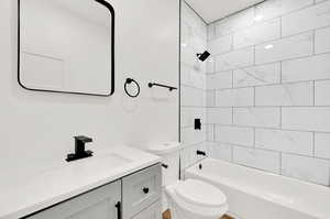 Full bathroom featuring vanity, toilet, and tiled shower / bath