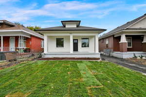 View of front facade with covered porch and a front lawn