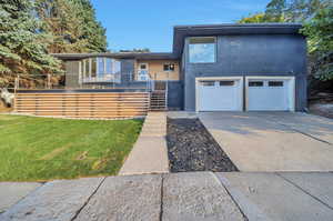 Contemporary home featuring a front lawn and a garage