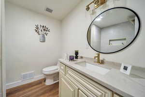 Bathroom featuring vanity, toilet, and hardwood / wood-style floors