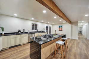 Kitchen featuring appliances with stainless steel finishes, a kitchen bar, sink, light hardwood / wood-style floors, and a center island