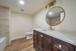 Full bathroom featuring vanity, separate shower and tub, hardwood / wood-style flooring, and toilet