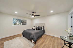 Bedroom with ceiling fan and light hardwood / wood-style flooring