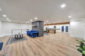 Living room with french doors and light wood-type flooring