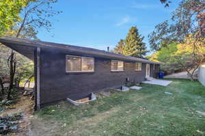 Rear view of house featuring a lawn