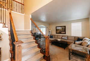 Living room with light carpet and a textured ceiling