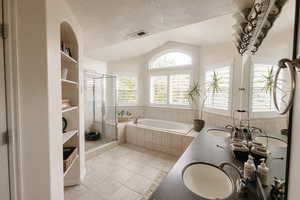 Bathroom featuring vanity, a textured ceiling, separate shower and tub, and tile patterned flooring