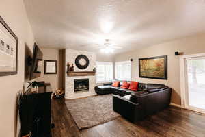 Living room featuring a textured ceiling, a healthy amount of sunlight, and oak wood flooring