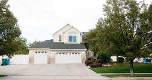 View of front of property with a front yard and a garage