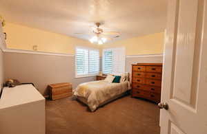 Bedroom featuring carpet floors, a textured ceiling, and ceiling fan