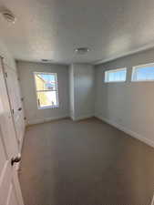 Unfurnished bedroom with visible vents, baseboards, multiple windows, and light carpet