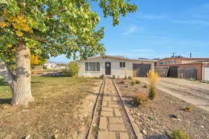 Front of home featuring a paved walkway, small sitting area, flower beds, and attached one car garage