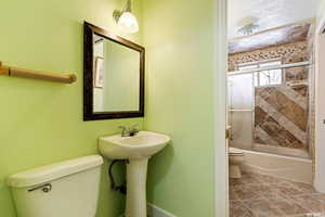 Bathroom featuring toilet and tiled shower / bath combo