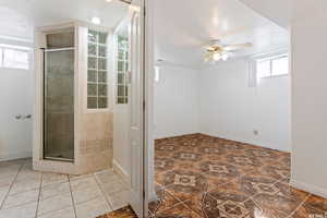 Bathroom featuring tile patterned flooring, ceiling fan, plenty of natural light, and an enclosed shower