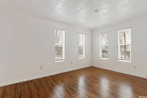 Spare room with crown molding, a textured ceiling, and hardwood / wood-style flooring