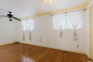 Spare room with crown molding, hardwood / wood-style floors, a textured ceiling, and ceiling fan