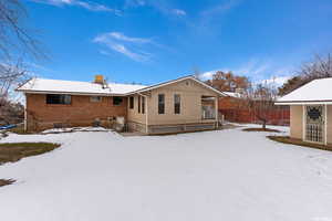 View of snow covered back of property