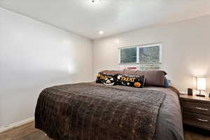 Bedroom with dark hardwood / wood-style flooring