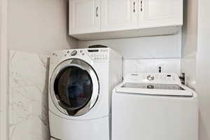 Laundry area featuring cabinets and separate washer and dryer