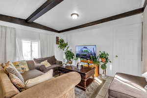 Living room featuring beam ceiling and light tile patterned flooring