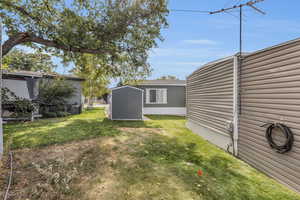 View of yard with a storage shed and central AC unit