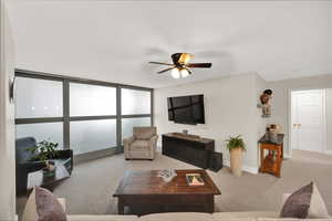 Carpeted living room featuring ceiling fan and beautiful sliding doors to 2nd bedroom.