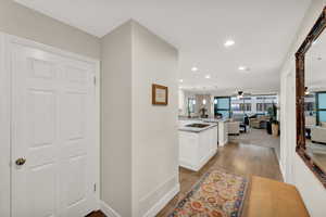 Condo entryway with hallway entering into kitchen/living/dining area.